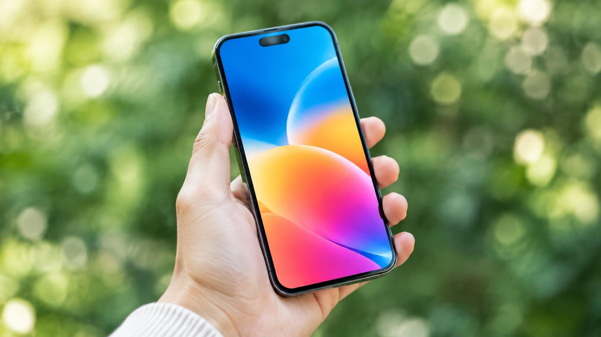 Smartphone held in hand showing a colorful screen